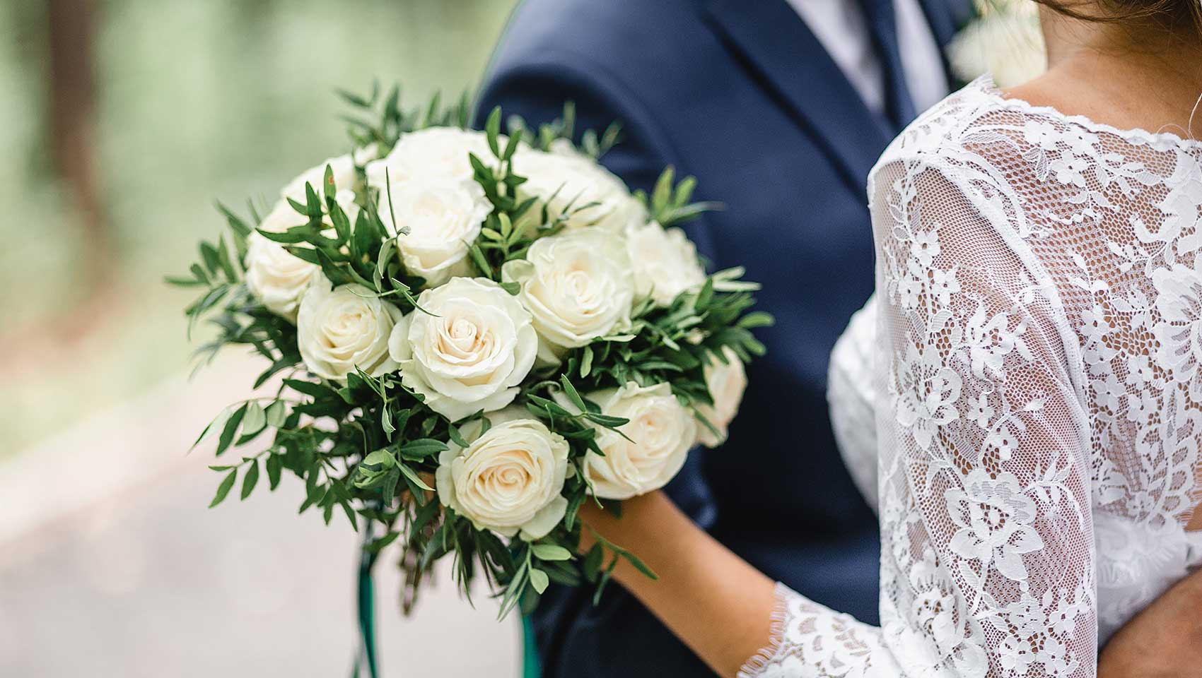 Bride holding white rose wedding bouquet