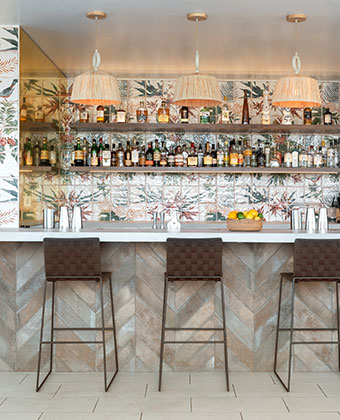 Videre rooftop bar area with high-top seating and liquor bottles behind the bar